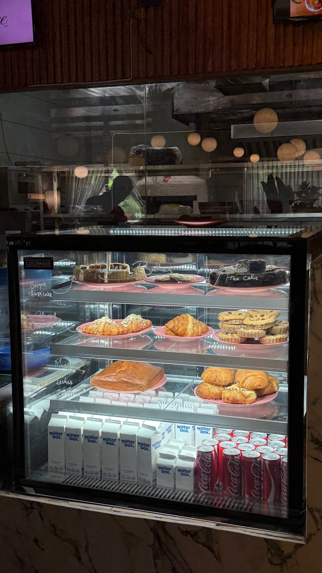 Glass display with Basque cheesecake and croissants